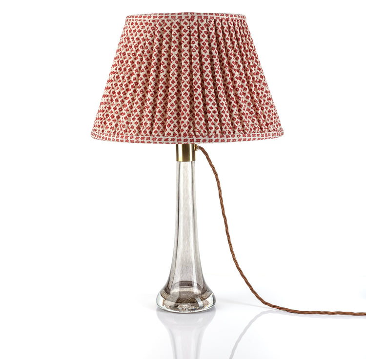 Table lamp with a patterned red and white shade on a white background