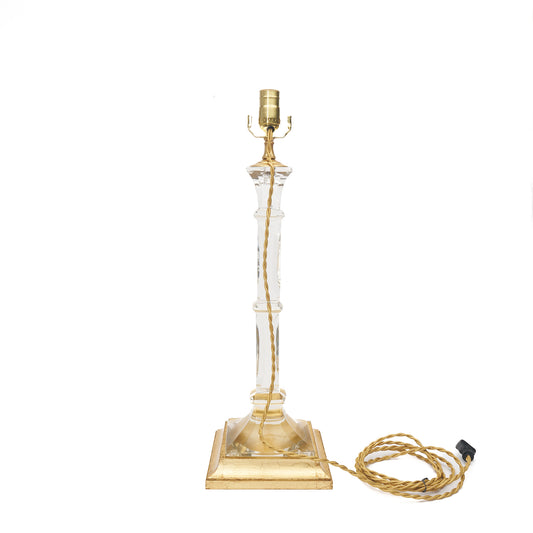 Table lamp with clear glass and gold base on a white background