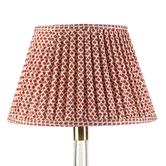 A red and white checkered lampshade with a gathered design on a lamp post.