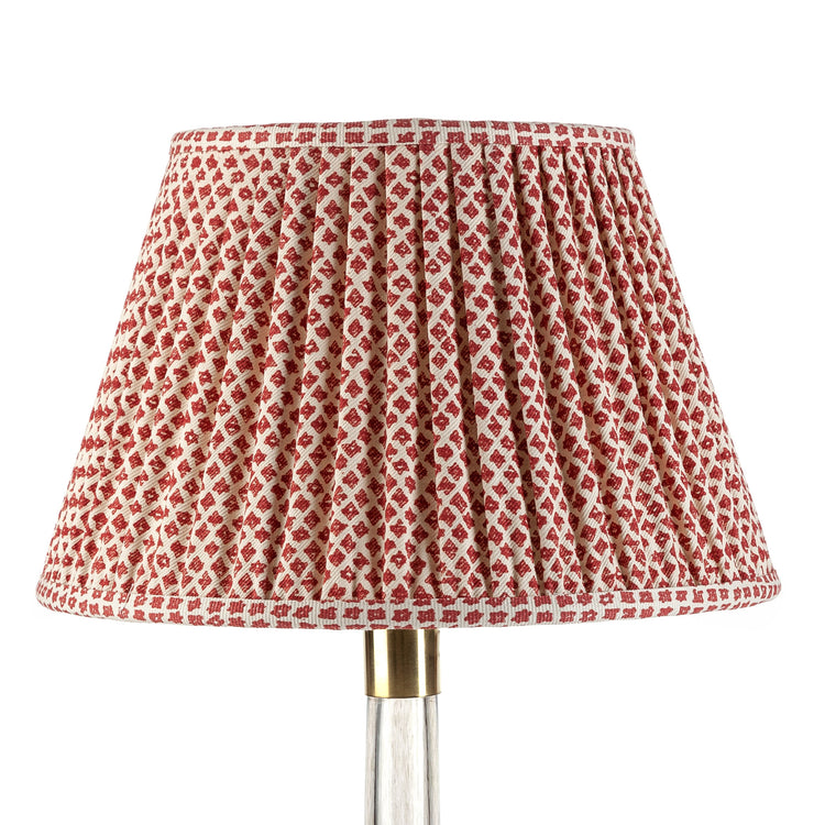 A red and white checkered lampshade with a gathered design on a lamp post.