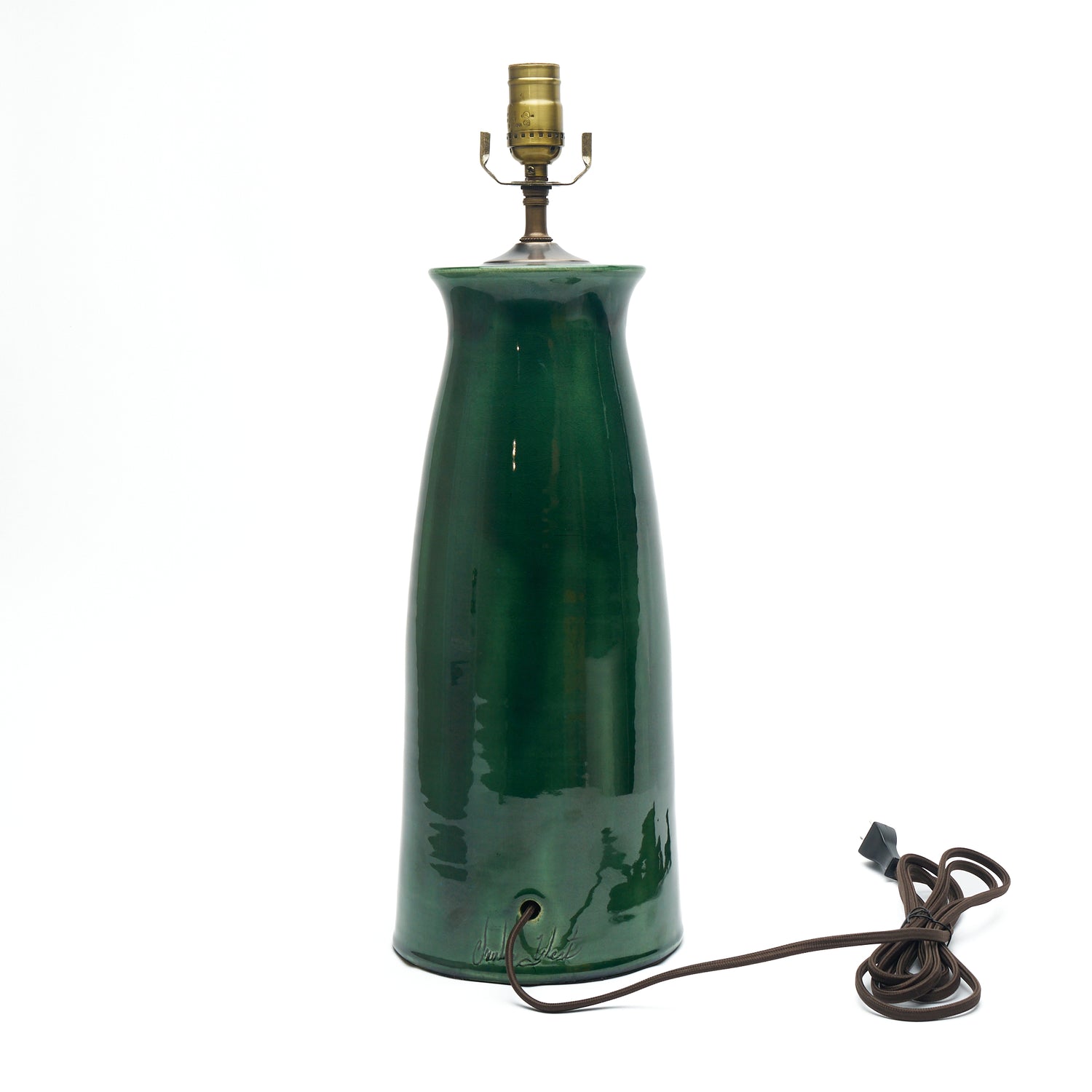 A dark green ceramic table lamp with a tapered base, a brass-colored metal socket at the top, and a dark brown power cord coiled on a white background.