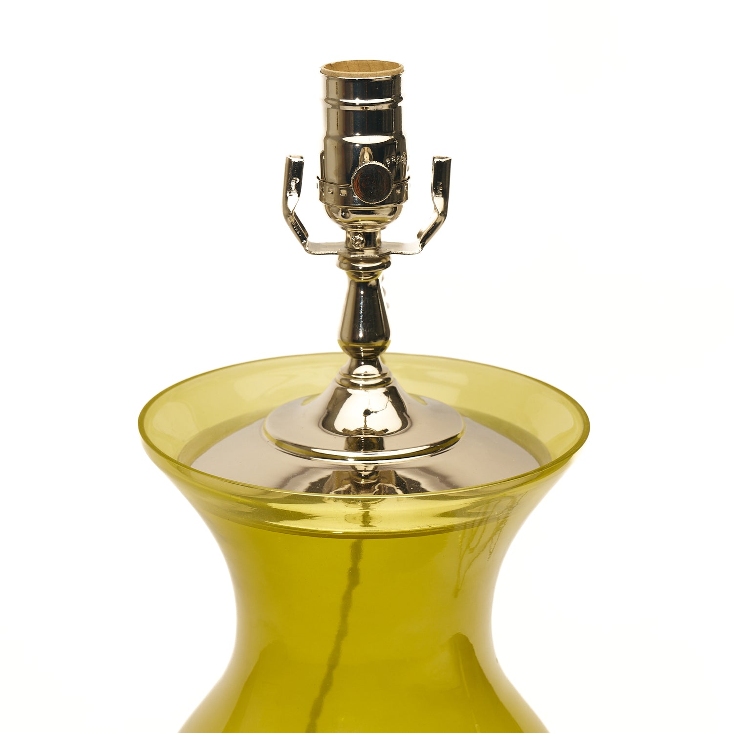 A close-up of a table lamp featuring citron green glass, a lucite base, and a polished silver metal socket, set against a plain white background.