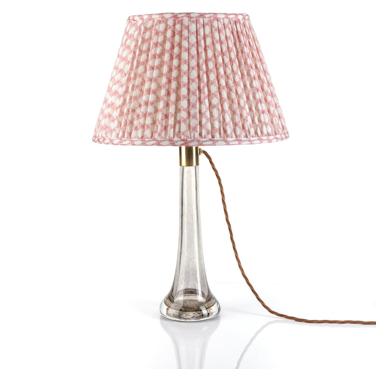 Table lamp with a pink checkered shade on a white background