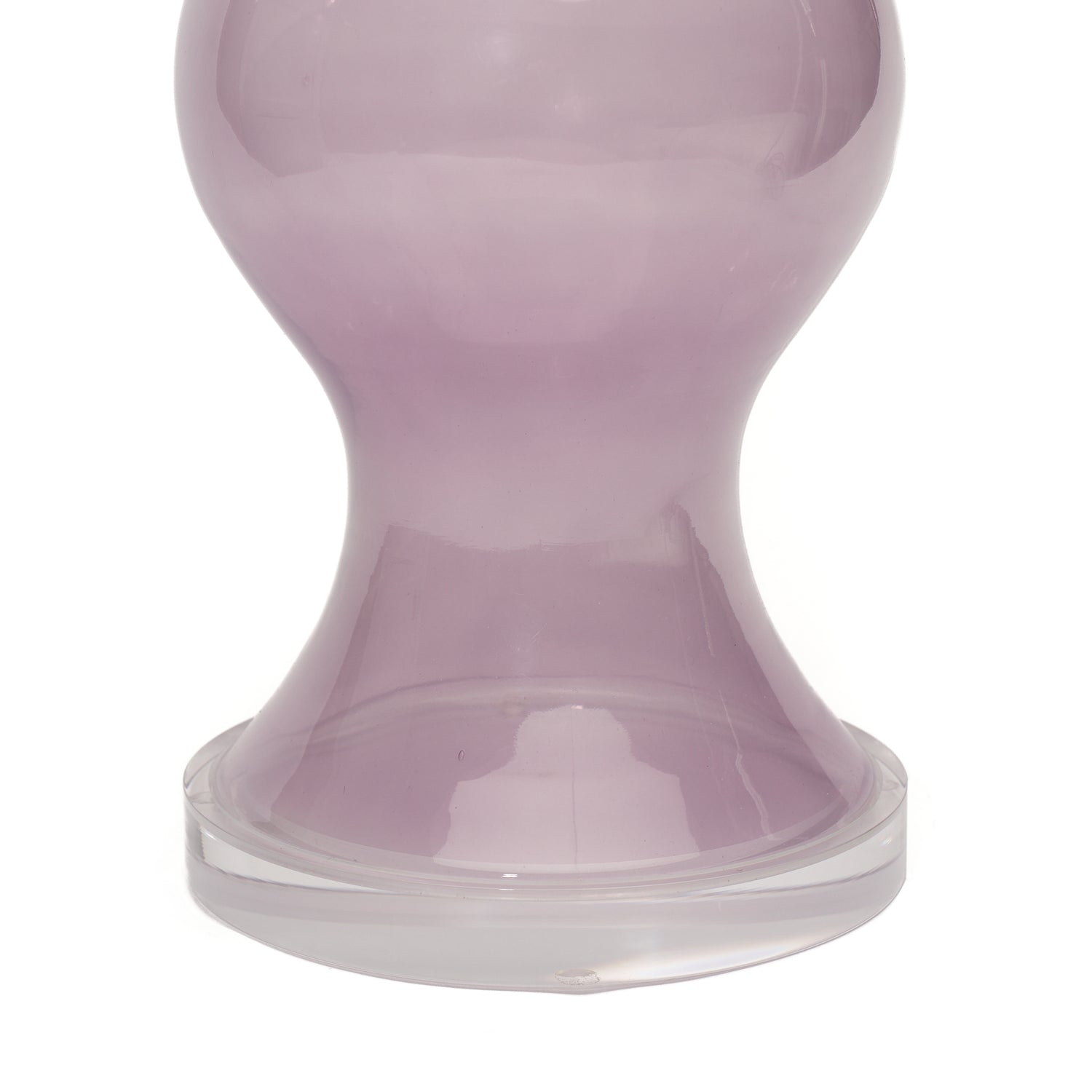 A close-up of a purple glass lamp with a lucite circular base, photographed against a white background.