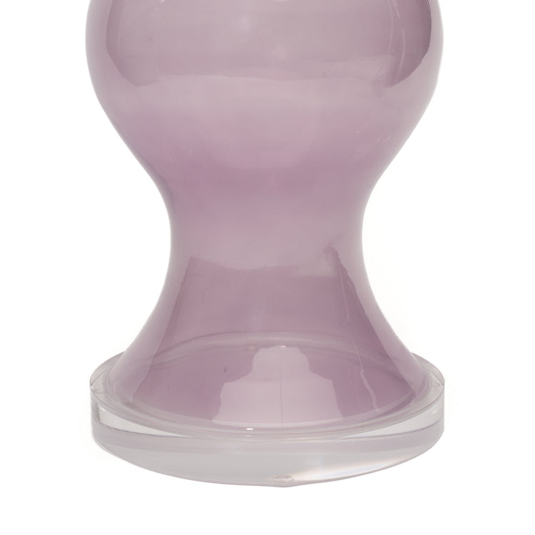 A close-up of a purple glass lamp with a lucite circular base, photographed against a white background.