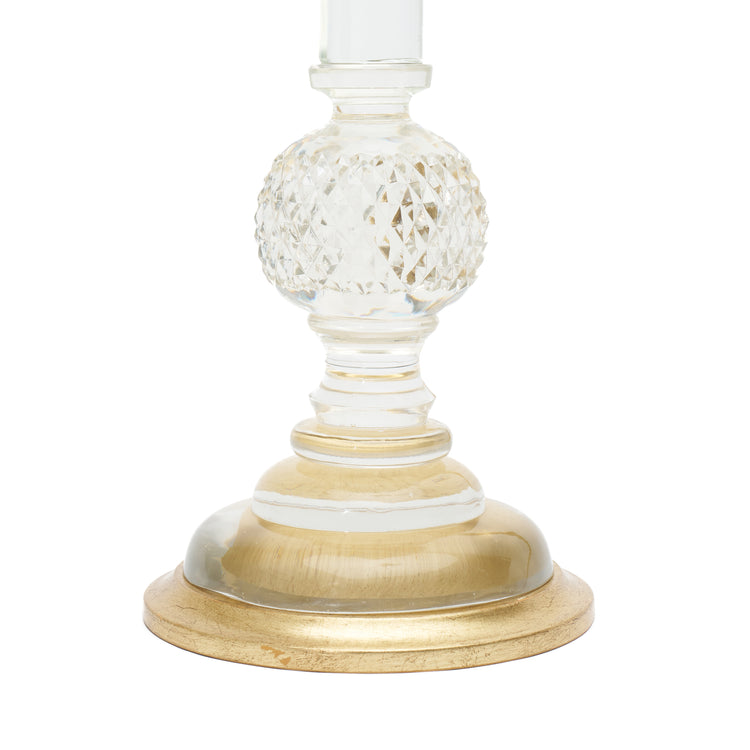 A close-up of a table lamp base featuring clear cut-glass, a clear glass stem, and a round gold-finished base on a white background.