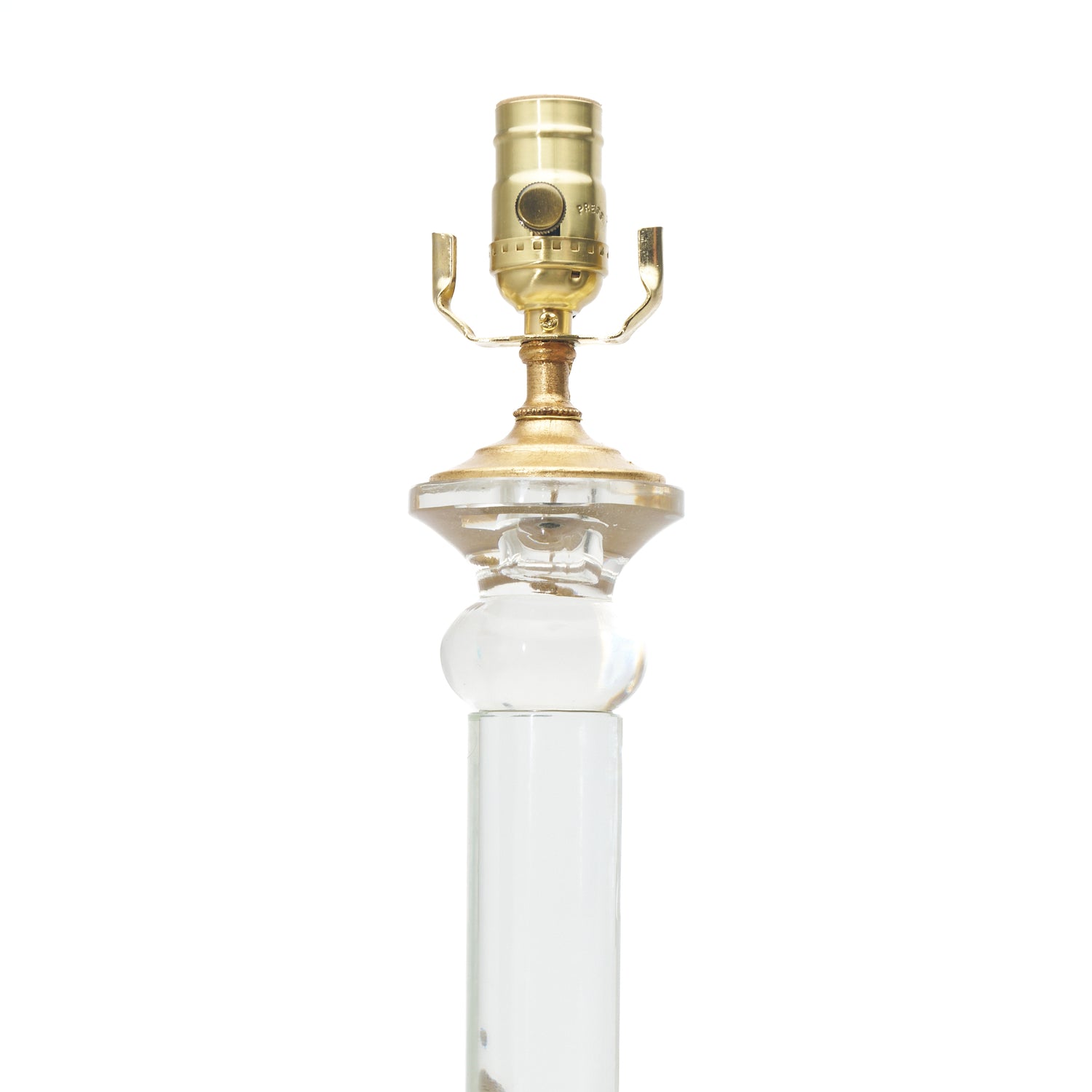 The top of an elegant table lamp with clear glass columns, textured crystal-like lower globes, and polished gold-finished bases and lamp fittings, shown against a plain white background.