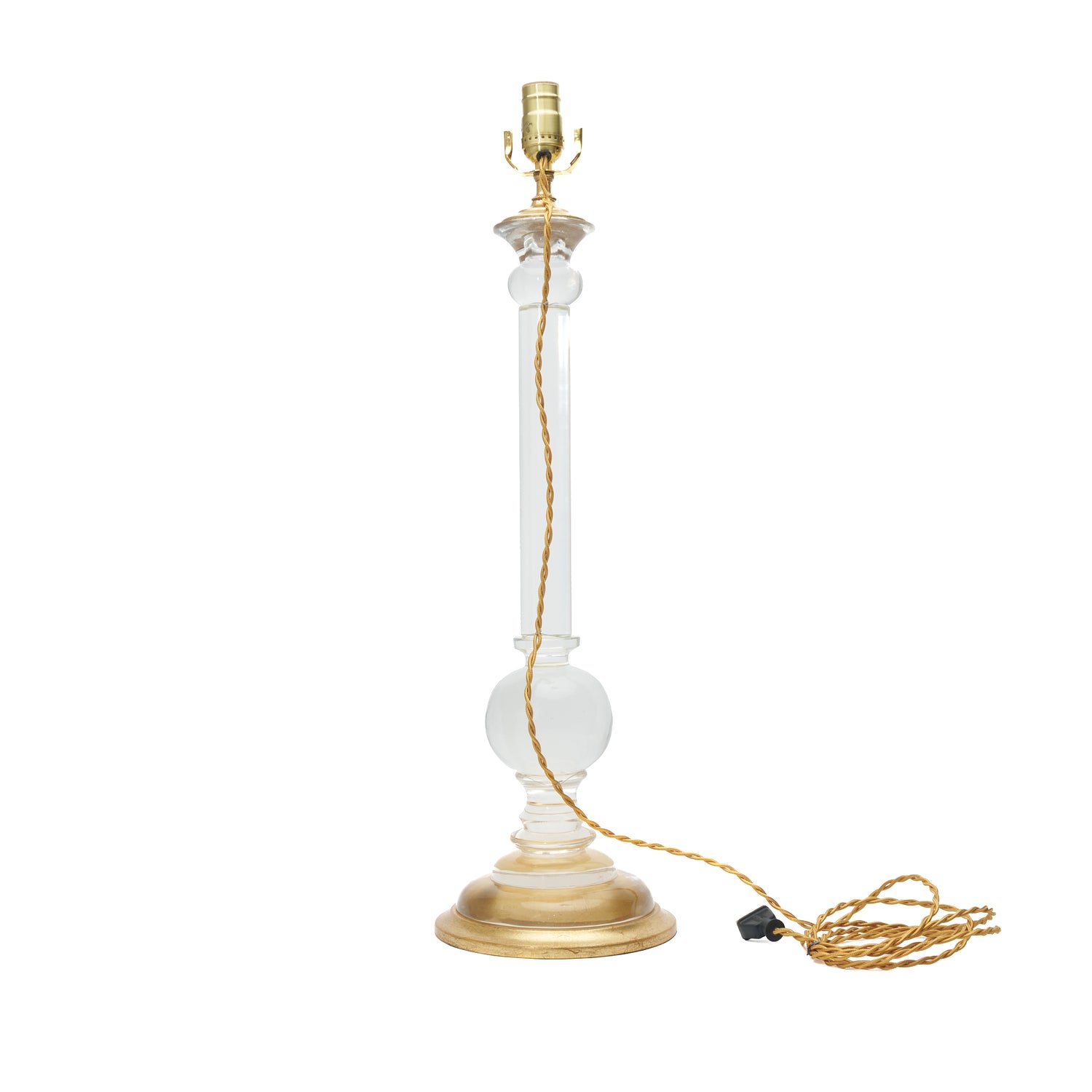 A table lamp with a clear glass column and a gold-finished base, socket, and cord, shown on a plain white background.