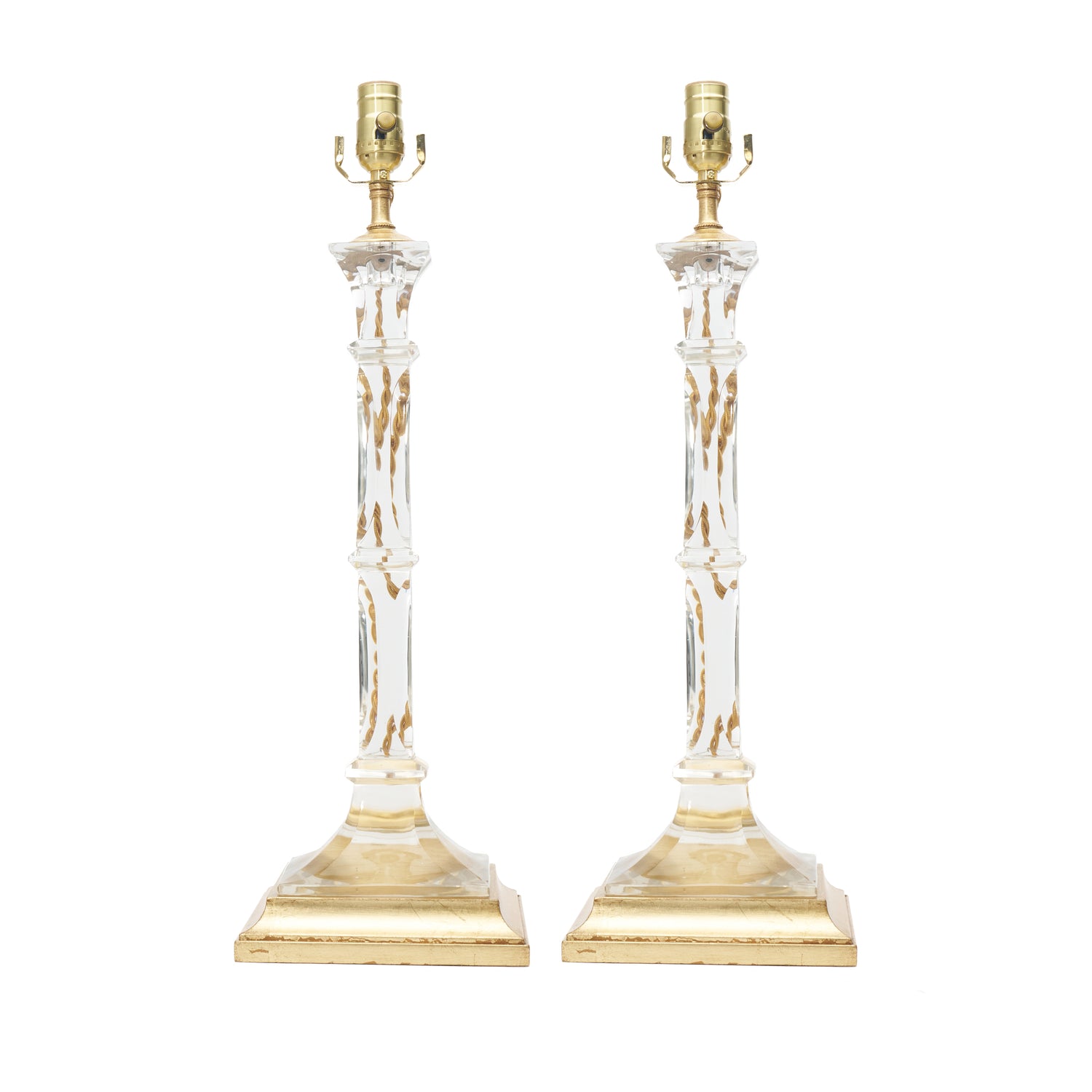 A pair of table lamps with clear glass columns, gold-finished bases, and bulb sockets, shown against a plain white background.