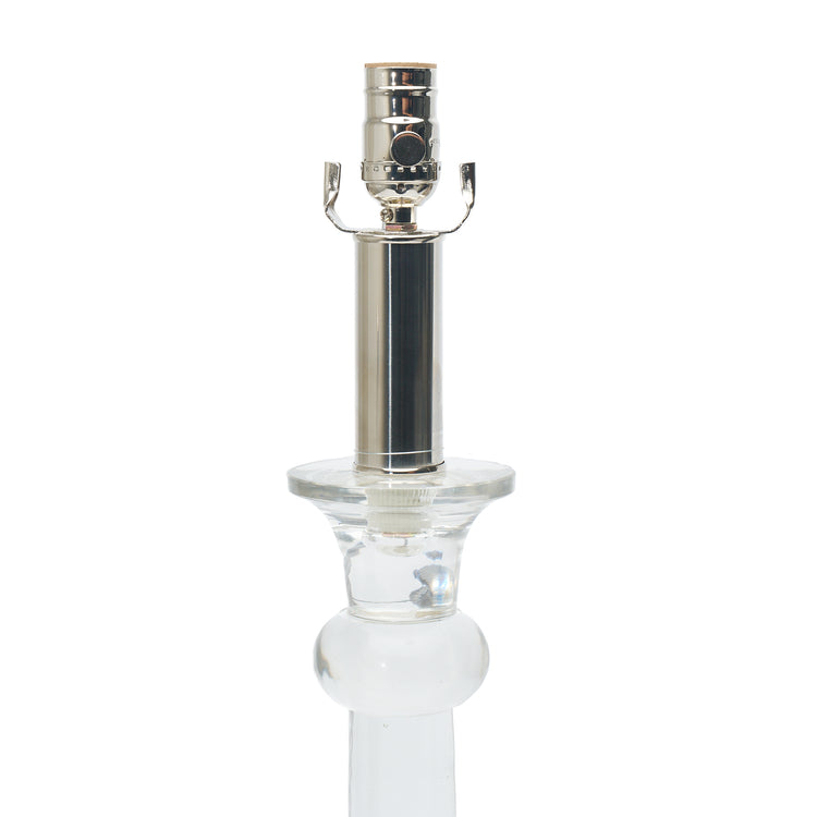 Clear glass table lamp with a nickel top on a white background