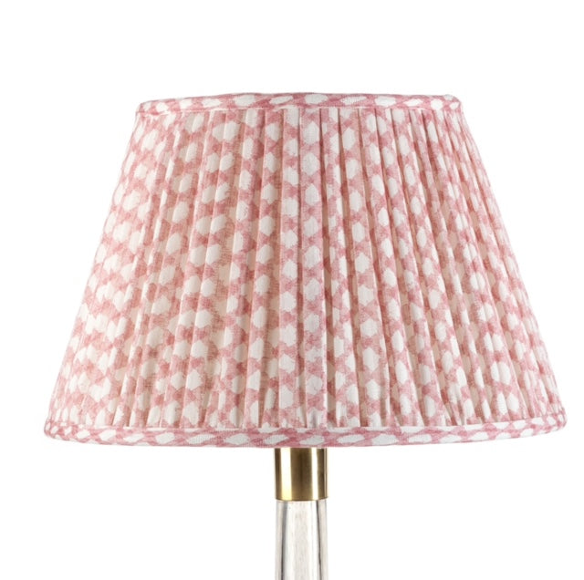 A pink linen wicker lampshade with a geometric pattern.